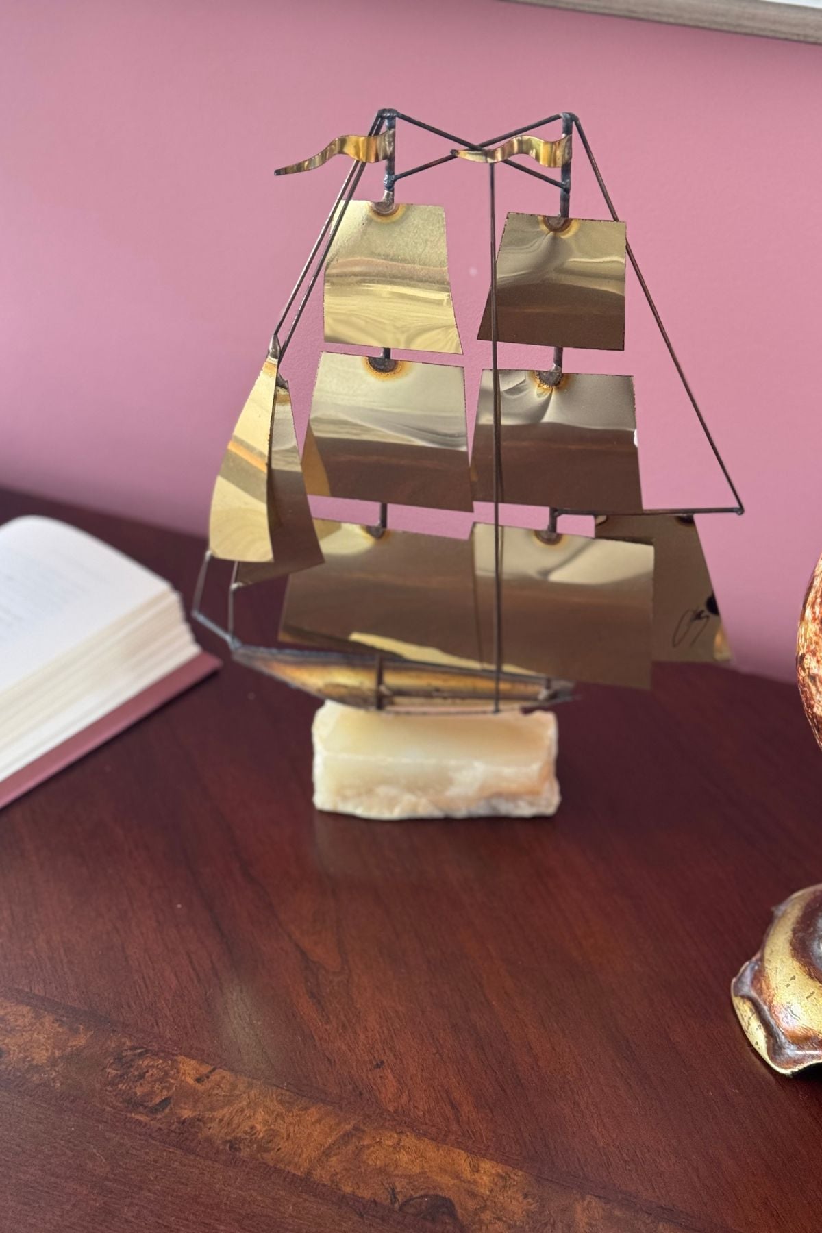 A brass sailboat on marble stand. Decorative item in the Beast's Library