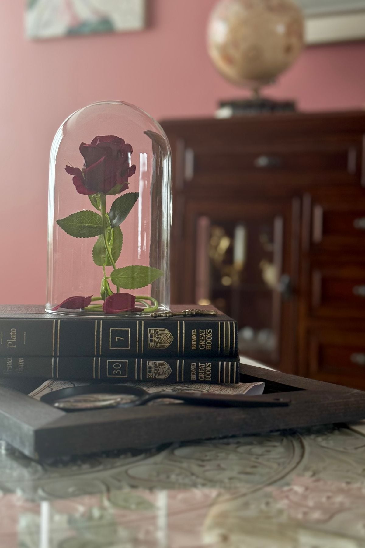 An Enchanted Rose on a stack of books, Beauty and the Beast inspired birthday party decor.