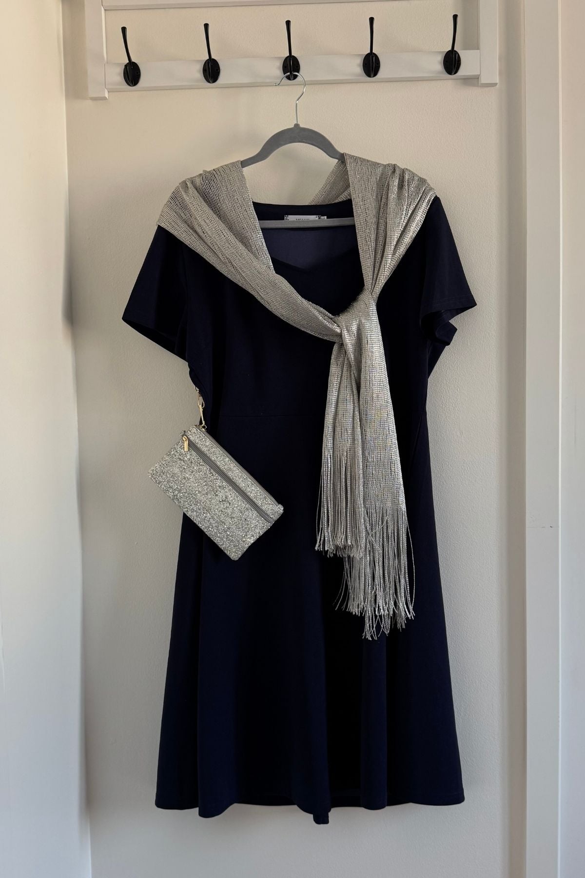 Christmas party outfit with a navy sweetheart dress, silver scarf, and a purse.