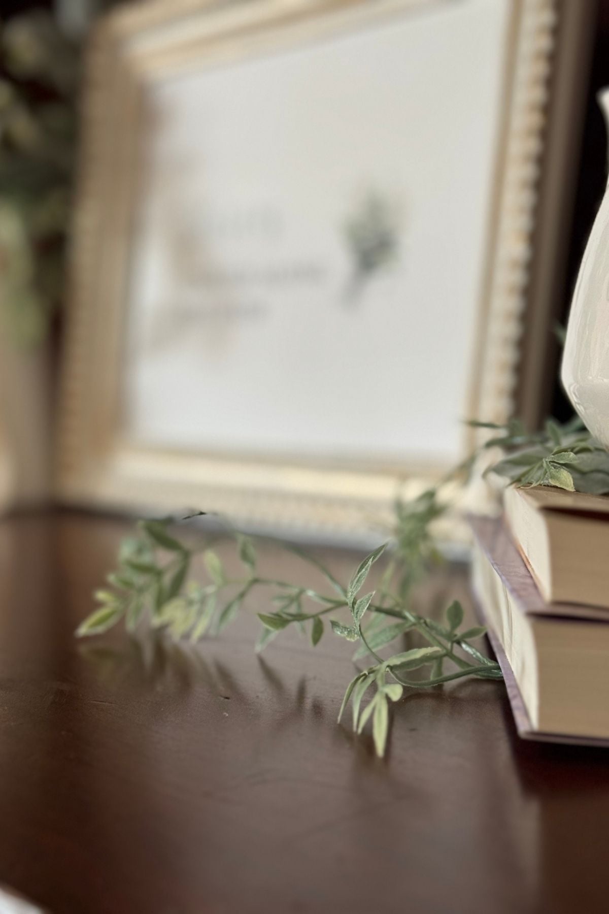 Spring greenery trailing from a stack of books.
