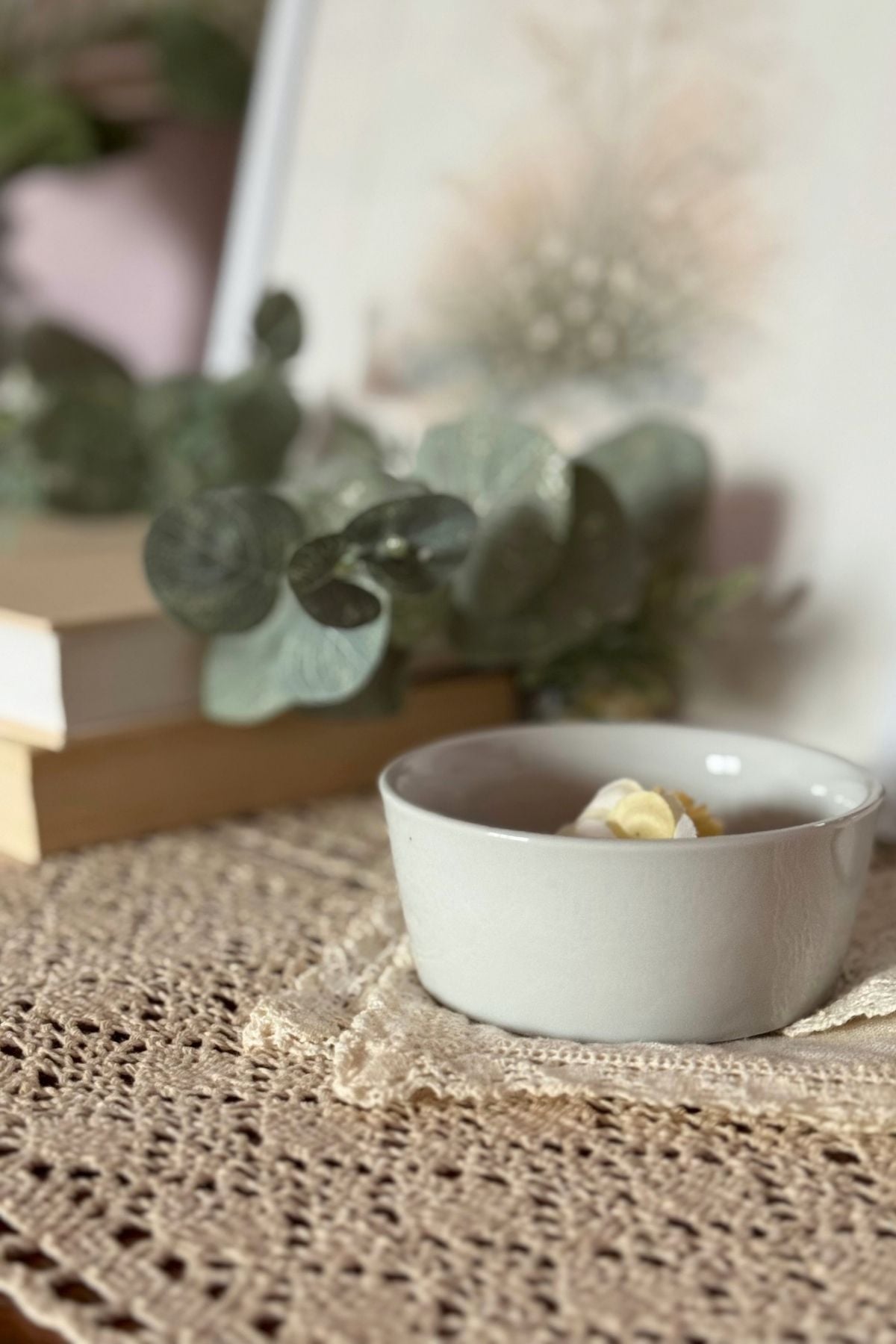 Layered lace and a ceramic bowl on a bedroom dresser