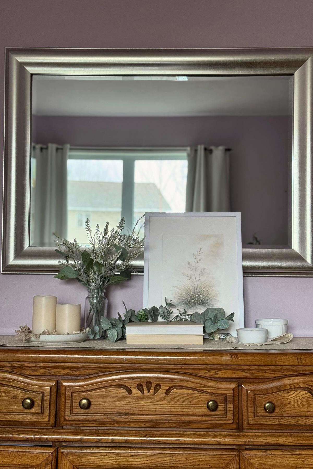 Bedroom dresser decorated with botanical printable, ivory candles, greenery, and airy florals.