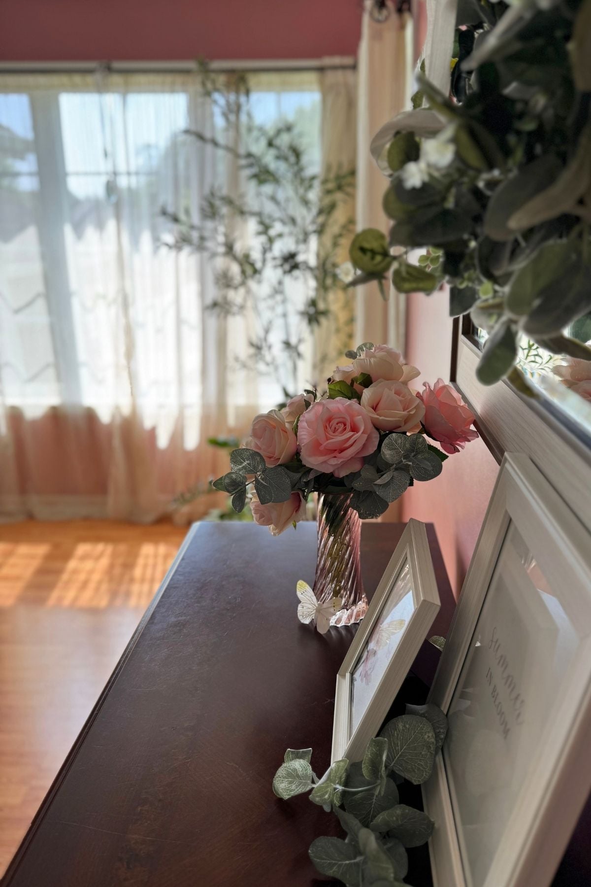 pink roses on dark wood credenza Blush pink roses on a dark wood credenza in the Storybook Cottage living room.