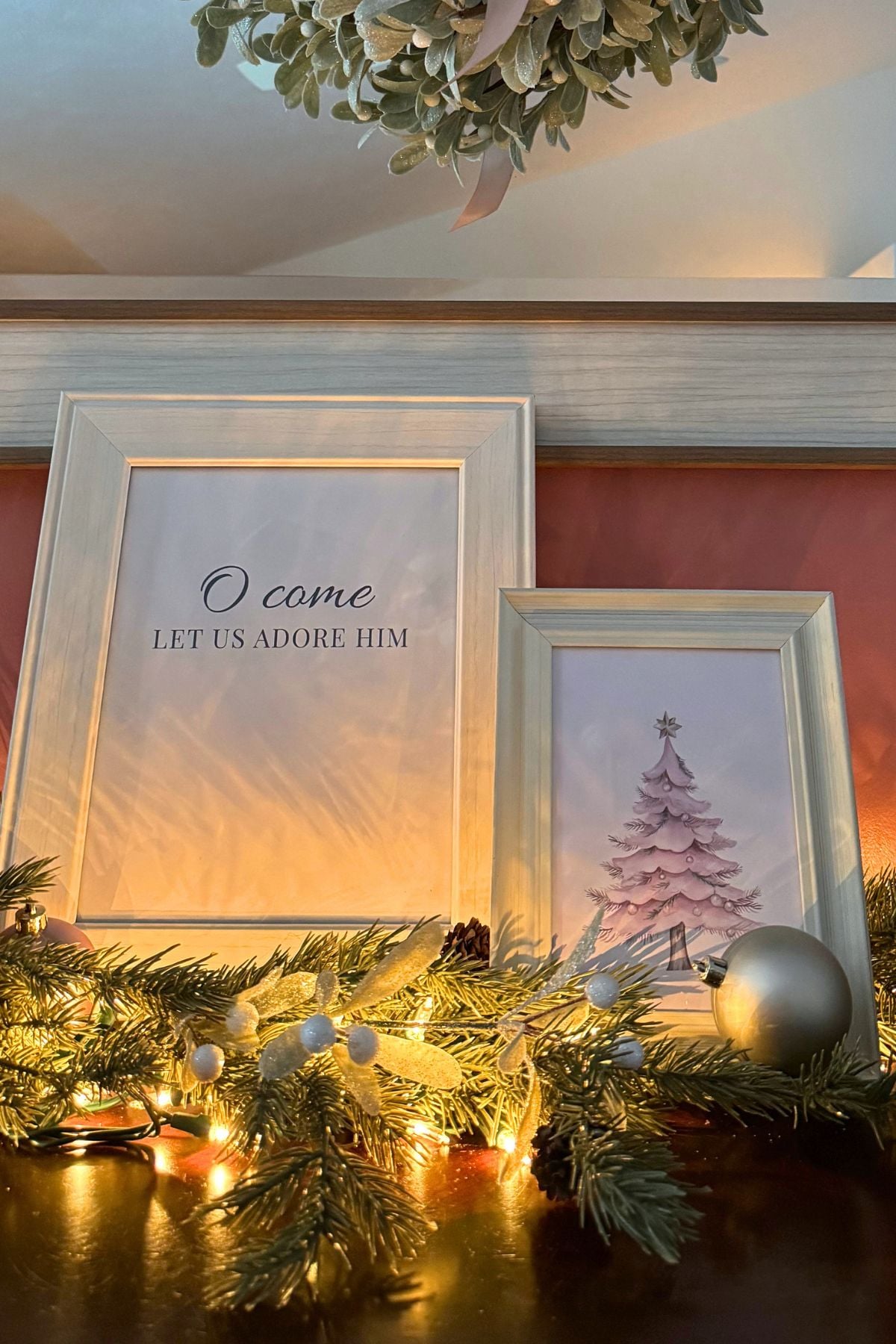 Christmas storybook signs in ivory frames on the sideboard (1) Christmas artwork in cream frames on sideboard: a blush Christmas tree and O Come Let Us Adore Him signs