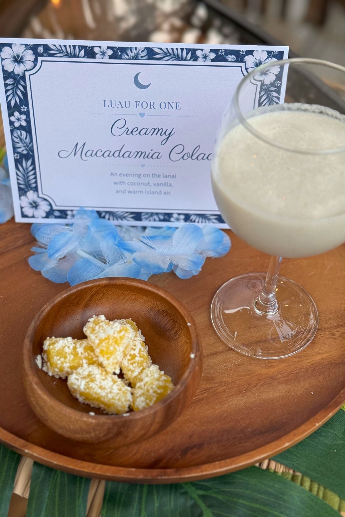 acacia wood tray Acacia wood tray decorated with a blue lei, palm leaf, and tropical drink.