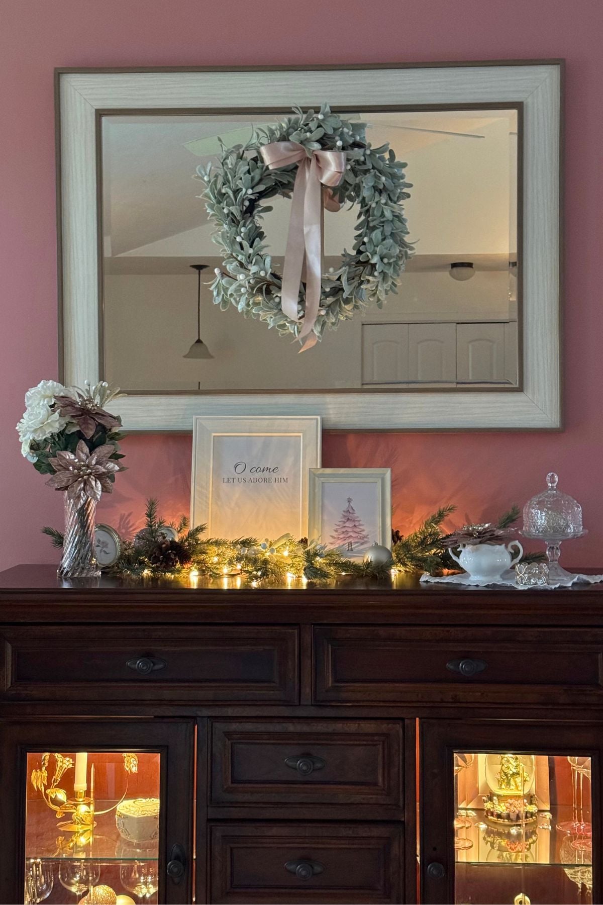 blush and cream christmas sideboard styling in storybook cottage Storybook Cottage living room, The Rose Parlour, Christmas sideboard with blush poinsettias, evergreen garland, candlelight, and framed signs