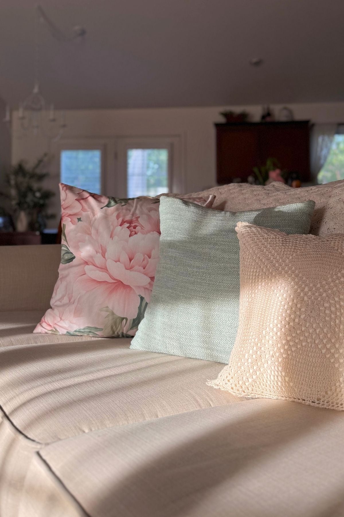 garden inspired throw pillows for cottage living room Garden-inspired throw pillows in cream, sage, and floral on a beige couch.