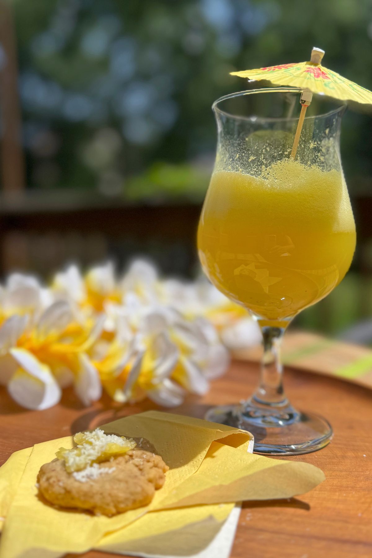 Tropical beverage: Ginger Pineapple Fizz on a tray decorated with a lei.