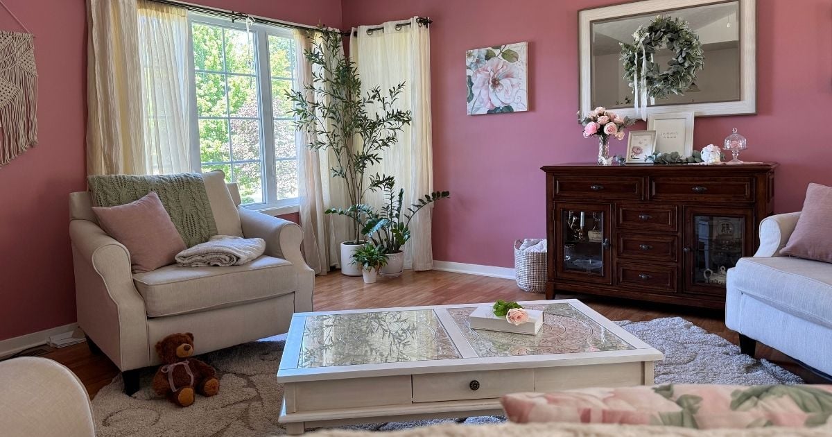 green and pink color palette for small living room Sage green and pink living room. Beige couch, cottage white coffee table, dark wood credenza. Pink and green accents. Romantic rose wall color.