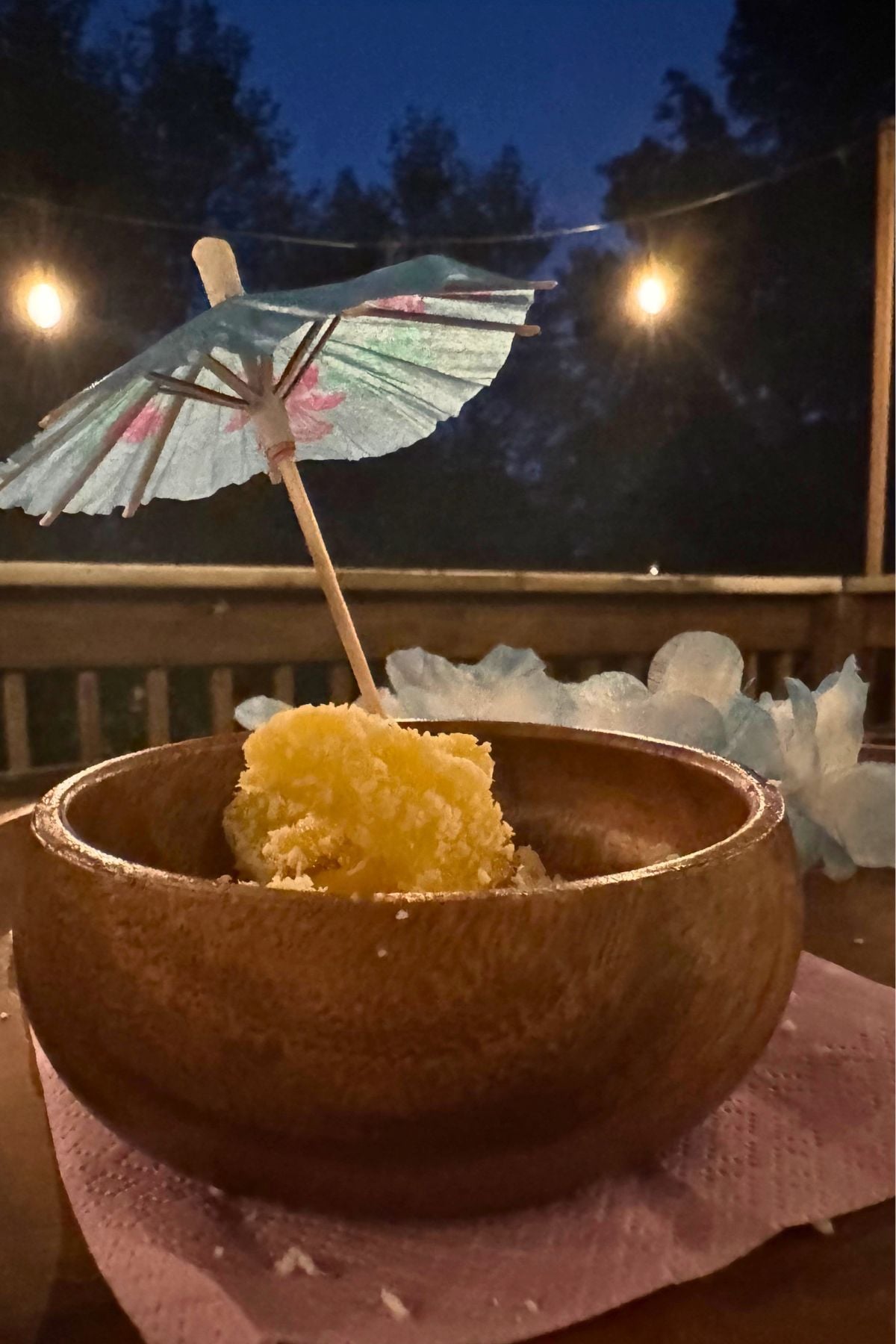 pineapple bites in acacia bowl (2) Tropical drink umbrella used as a fruit fork for pineapple bites.