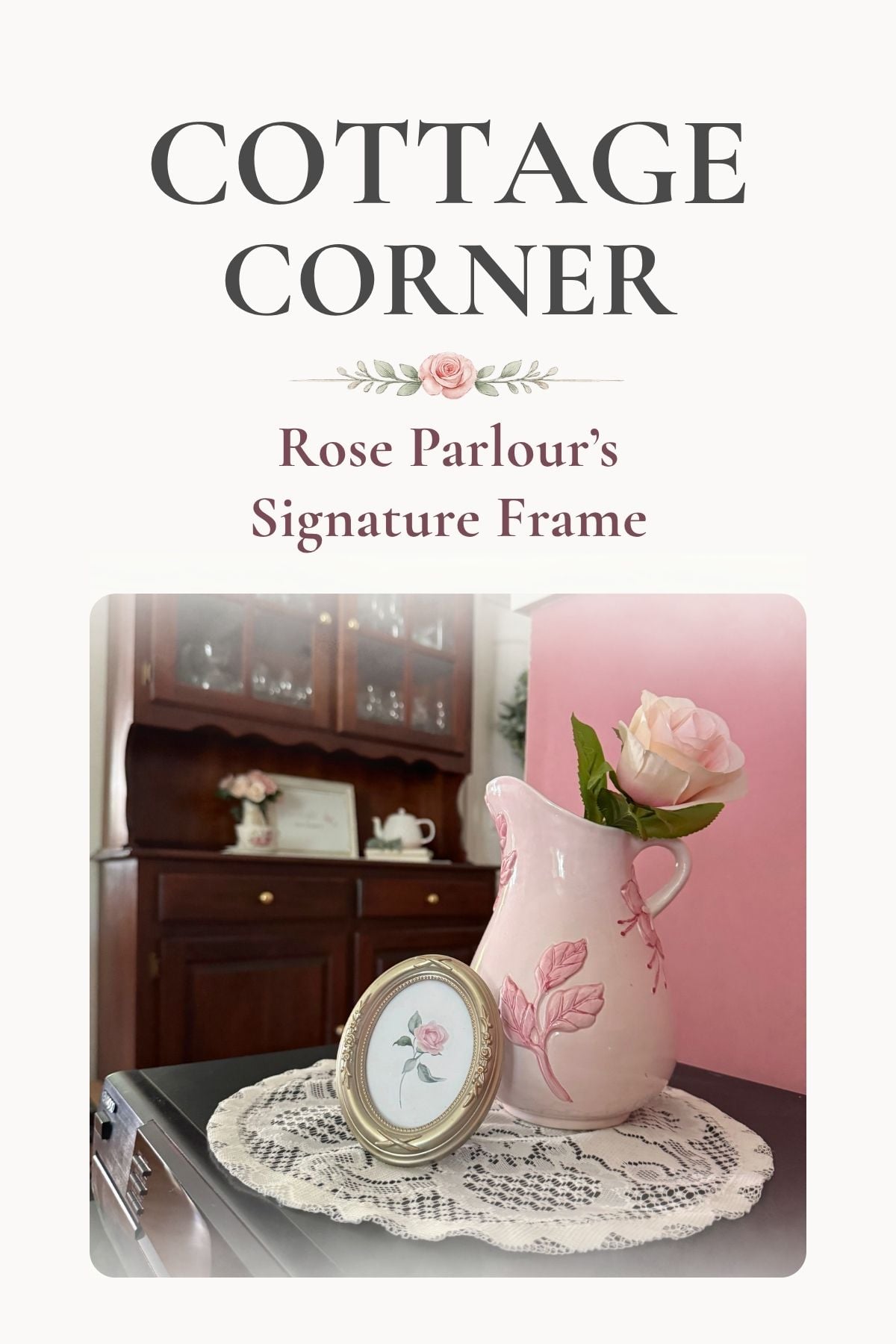 pink cottage pitcher A single rose art in an oval frame next to a pink ceramic pitcher in a cottage-style home.