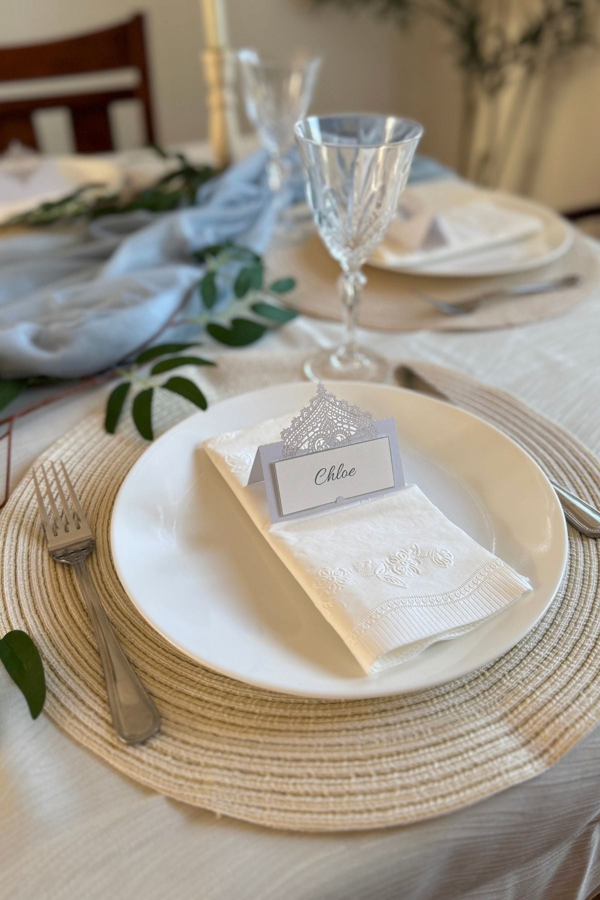 rivendell-inspired-place-setting Rivendell-inspired place setting with a round cream placemat, white plate and napkin, crystal wine glass, and silvery-white place card.